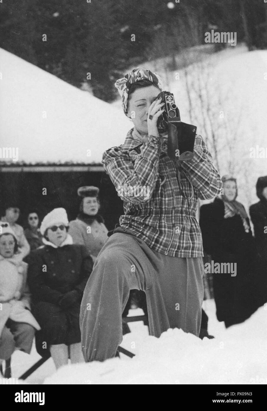 In inverno i 1940s. Una giovane donna è filmare il curling championships succedendo ad Åre in Svezia. 1940s. Foto Stock