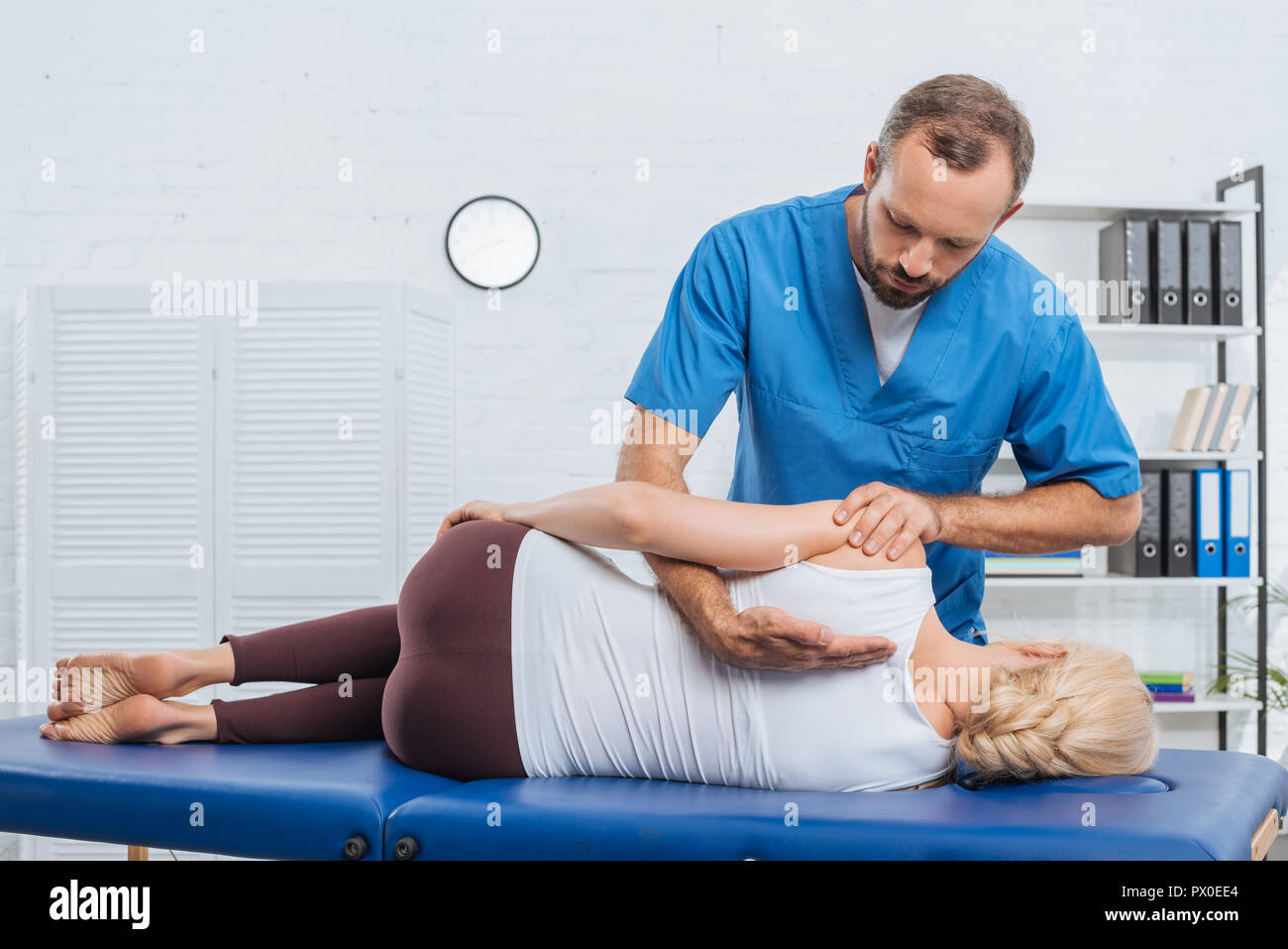 Massaggio chiropratico di schiena del paziente sdraiato sul lettino da massaggio in ospedale Foto Stock