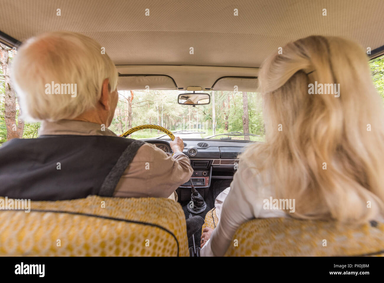 Vista posteriore della famiglia senior in auto d'epoca Foto Stock