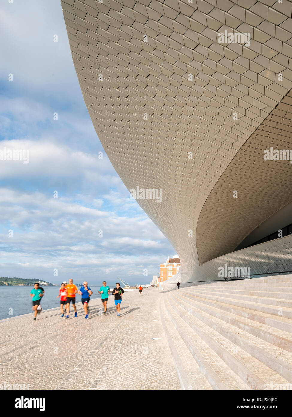 Vista esterna del MAAT - Museo di Arte, Architettura e Tecnologia, Lisbona, Portogallo. Gruppo di praticanti di jogging sui gradini della terrazza. Foto Stock