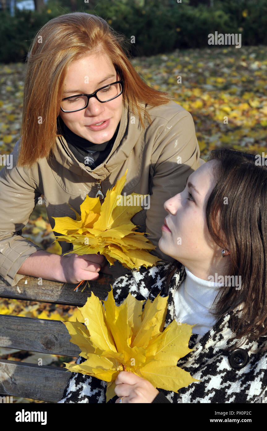 Due studentesse in appoggio in autunno park , in serie Foto Stock
