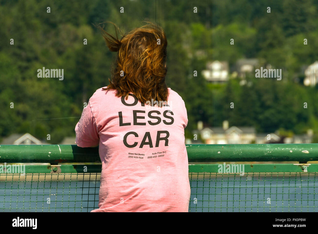 BREMERTON, NELLO STATO DI WASHINGTON, STATI UNITI D'AMERICA - Giugno 2018: Persona con una rosa 'uno meno auto' T shirt appoggiata sulla ringhiera di un traghetto passnger legato per Seattle. Foto Stock