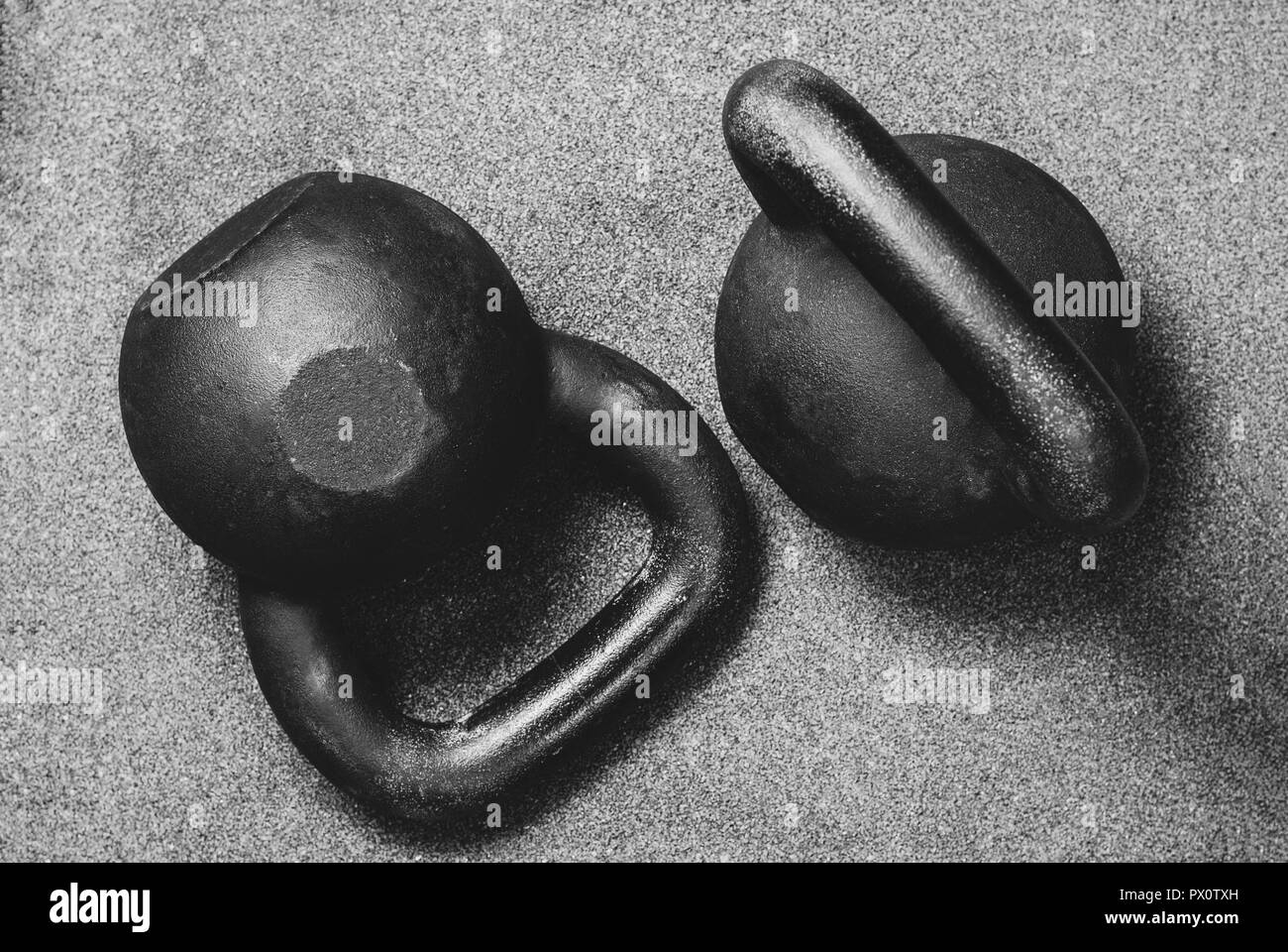 Due pesanti kettlebell nero su sfondo grigio Foto Stock