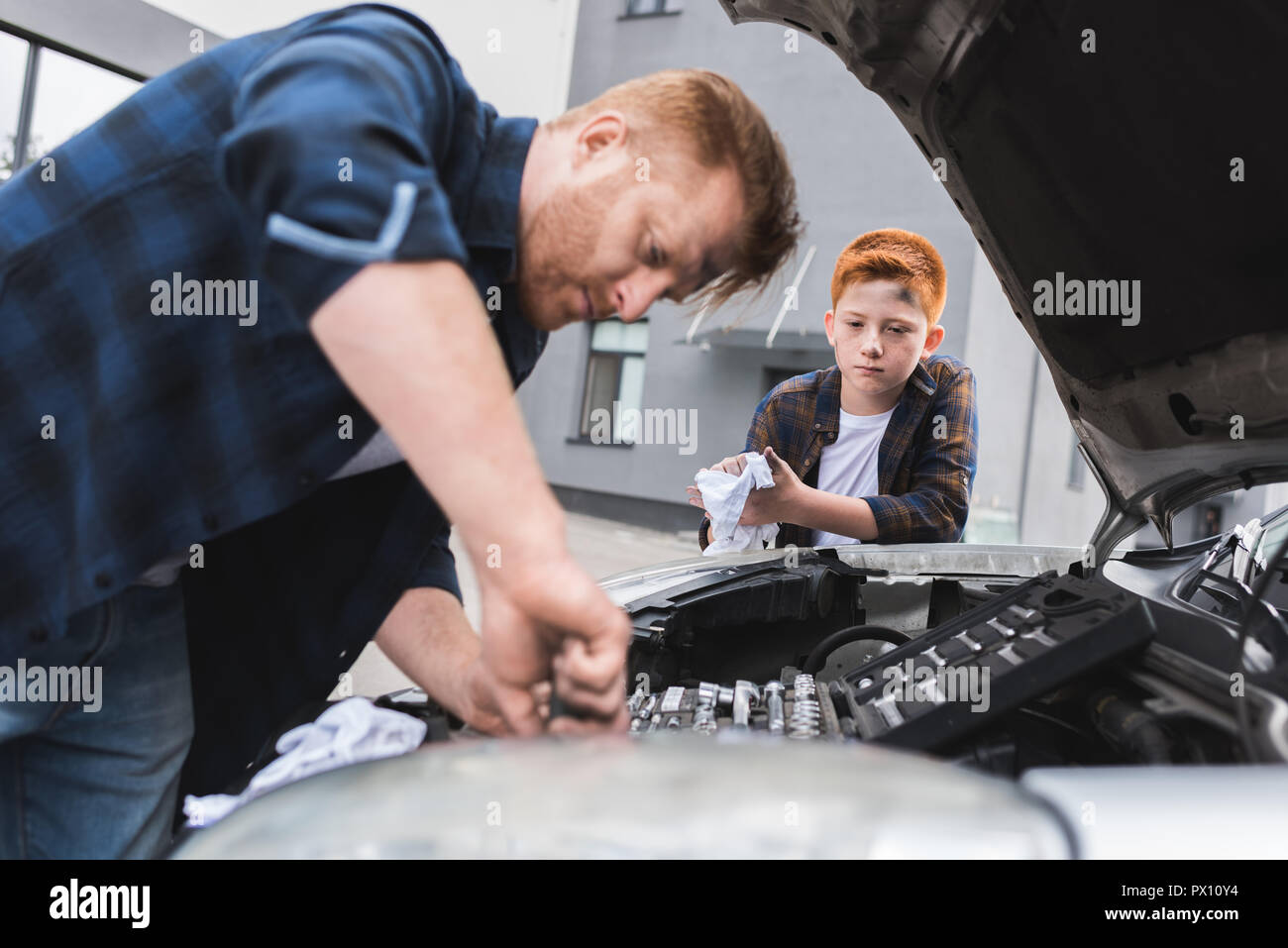 Padre e figlio riparazione auto con cappa aperta Foto Stock