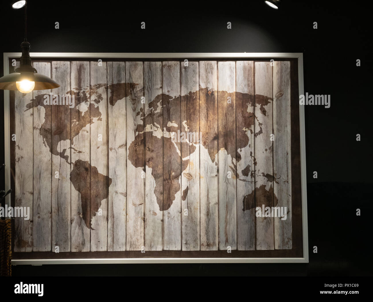 Legno mappa del mondo sulla parete presso il cafe ristorante dim in condizioni di luce scarsa. low key shot Foto Stock