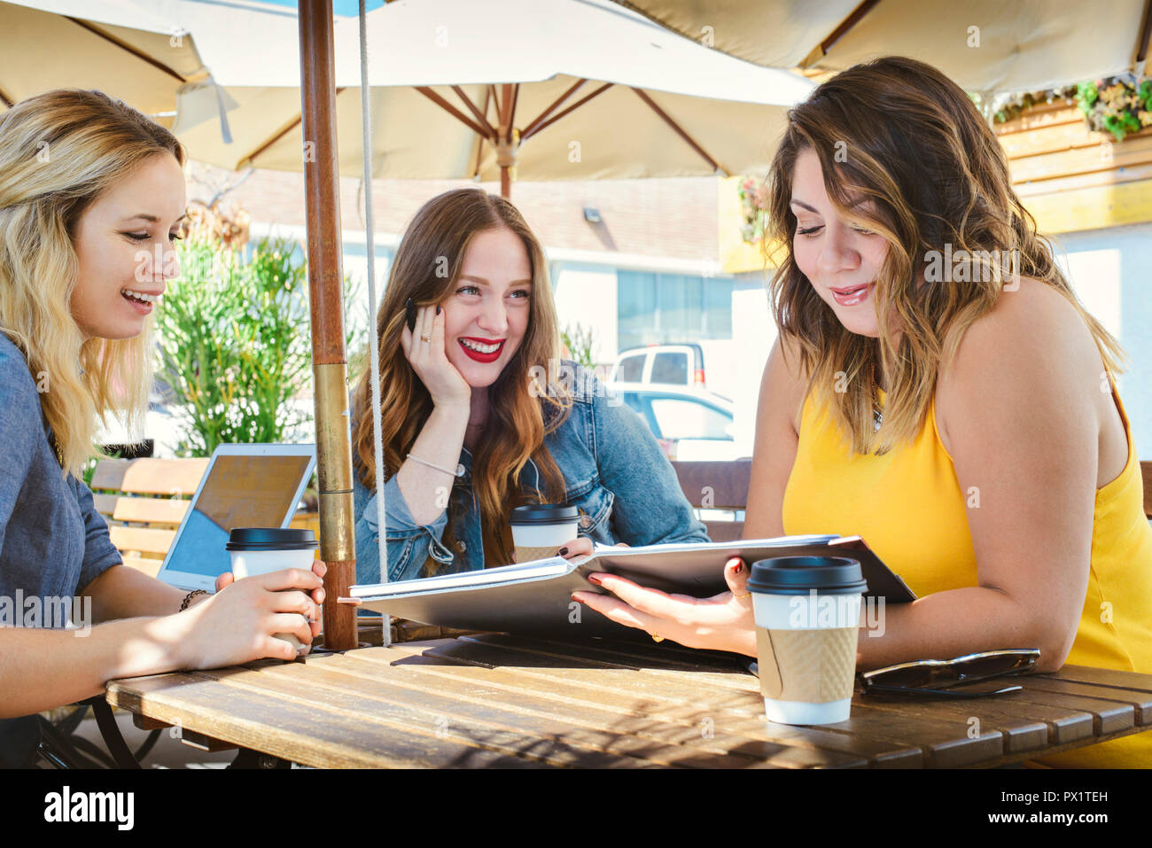 Un gruppo di giovani business millenaria che le donne hanno una riunione in un cafe Foto Stock