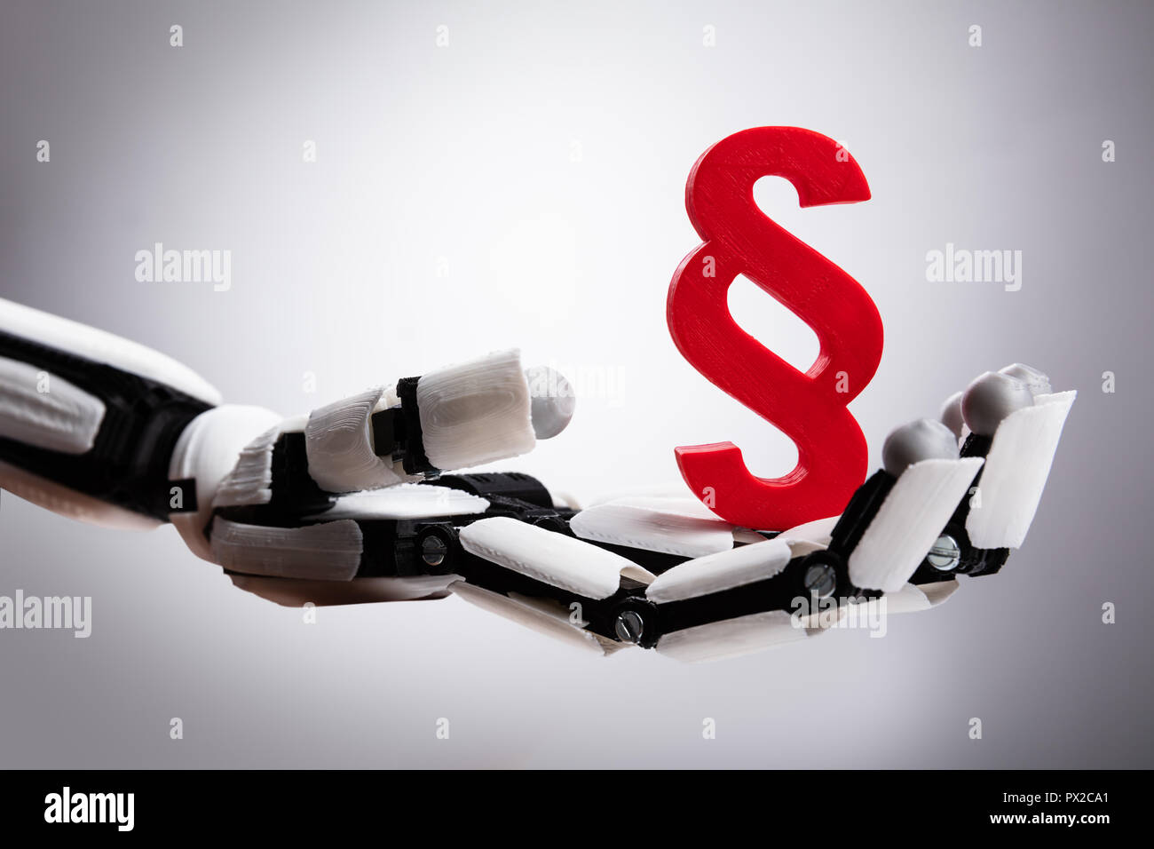 Close-up di un robot Holding paragrafo simbolo su sfondo grigio Foto Stock