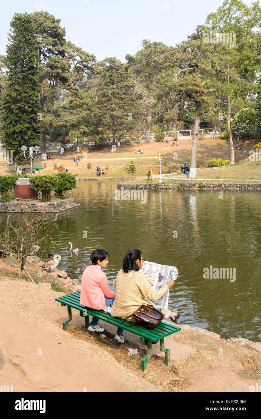 La gente che legge un giornale nel parco al Ward's Lake, Shillong, Meghalaya, India Foto Stock