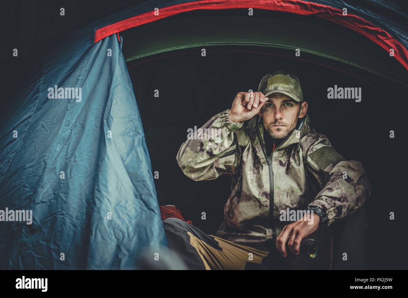 Caucasian Pro Hunter nel suo 30s Spotting Wildlife dalla sua tenda. Foto Stock
