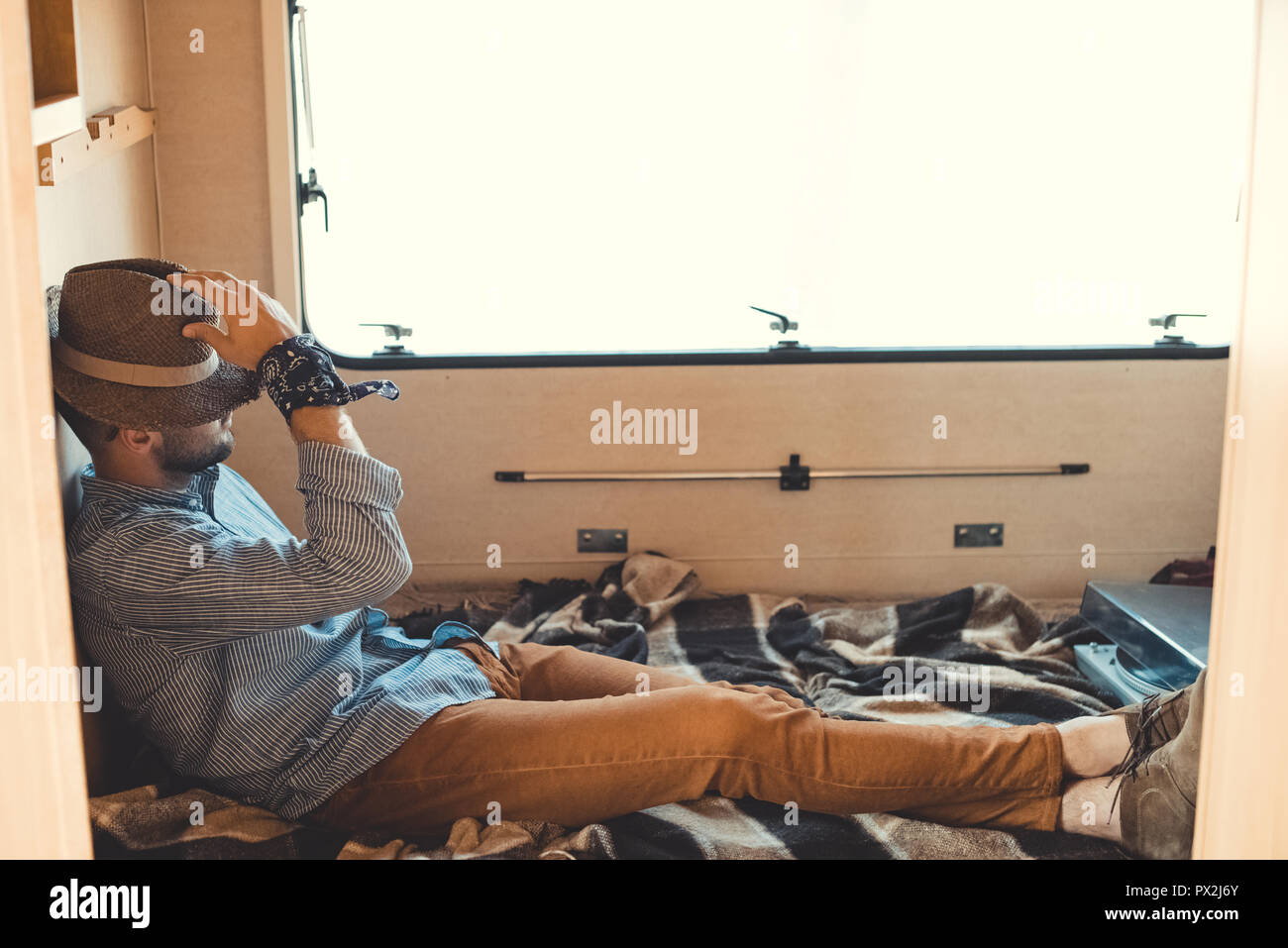 Uomo in hat seduta all'interno del camper con lettore di vinile Foto Stock