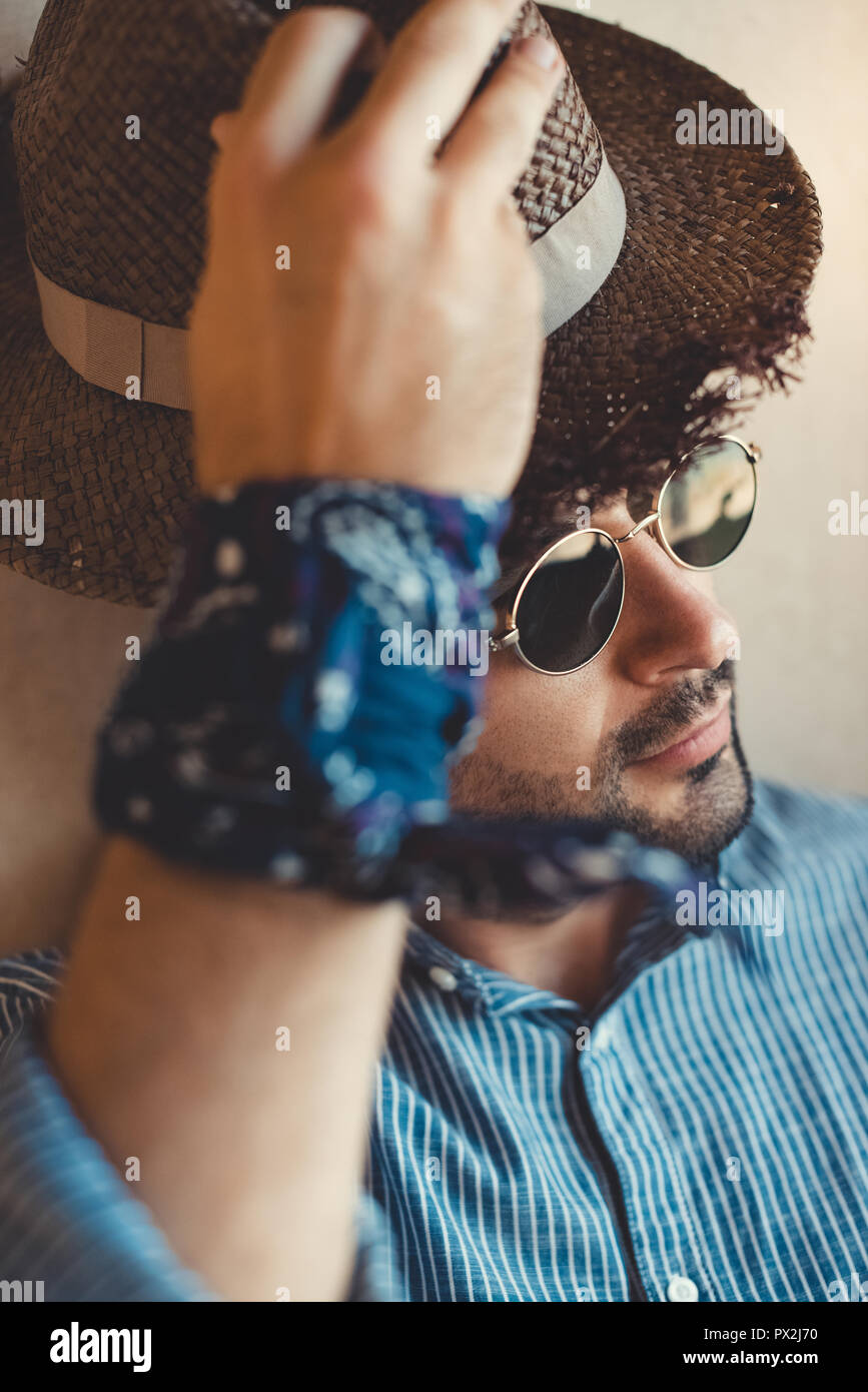 Uomo bello in occhiali da sole e cappello seduti all'interno del camper Foto Stock