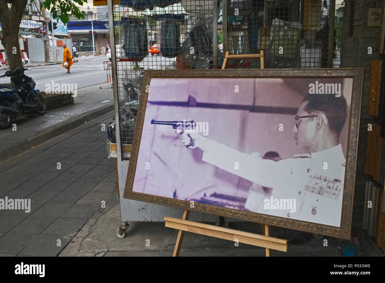 Un negozio situato nei pressi di numerosi negozi di pistola a Bangkok visualizza una rara foto di ex Re Tailandese Bhumipol Adulyadej, nella sua gioventù un appassionato di sport tiratore scelto Foto Stock