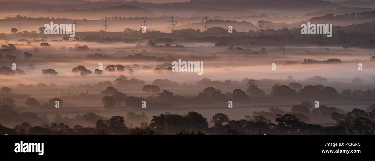 Marshwood, Dorset, Regno Unito. Il 19 ottobre 2018. Regno Unito Meteo: strati di early morning mist origine dai campi a sunrise creando una scena atmosferica. Credito: Celia McMahon/Alamy Live News Foto Stock