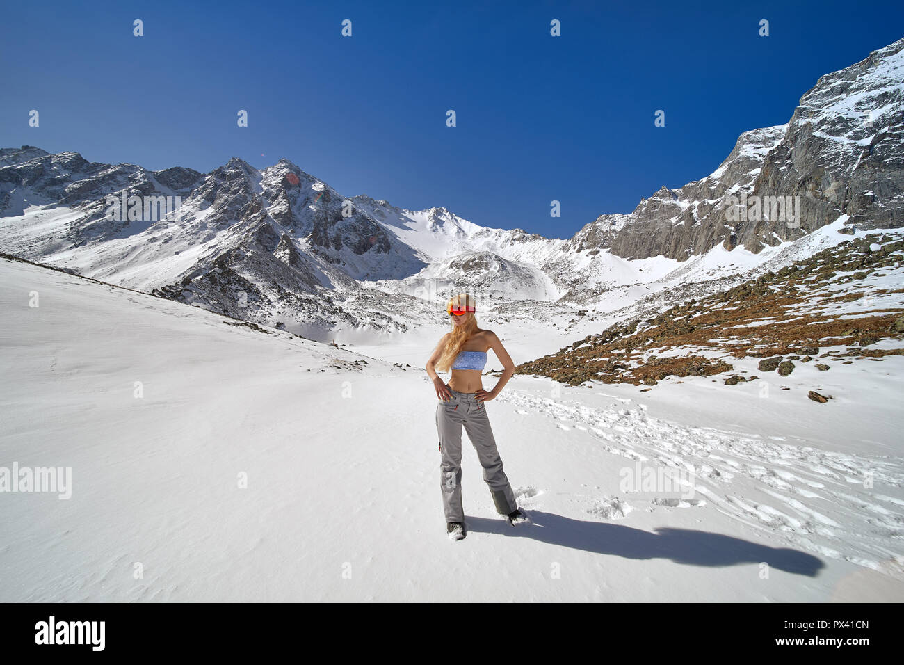 Modello in posa un costume da bagno e attrezzatura da sci in montagna. Foto Stock