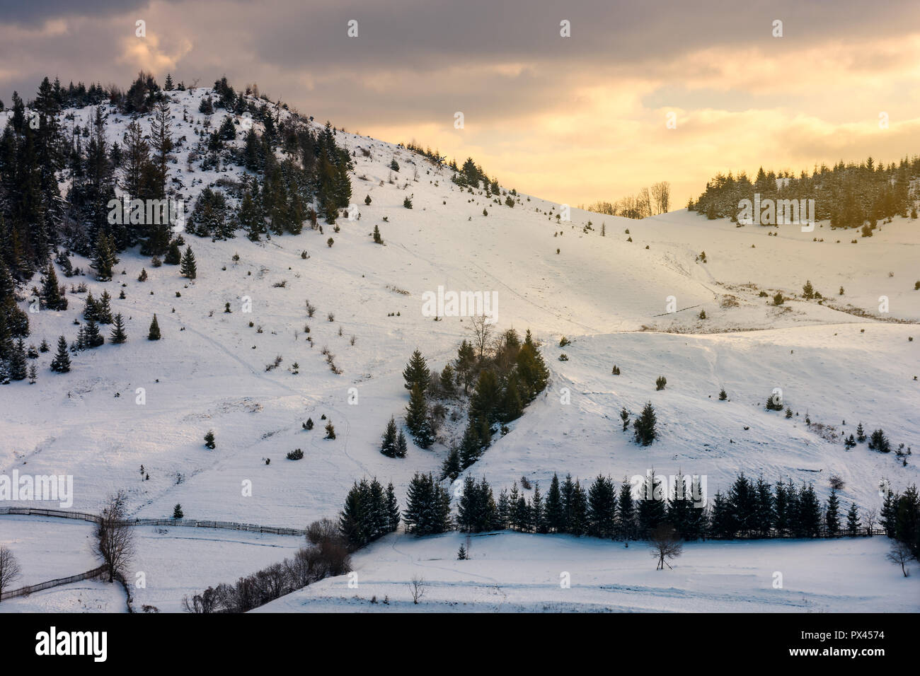 Bel tramonto in montagna. giallo cielo incandescente sopra la coperta di neve hill Foto Stock