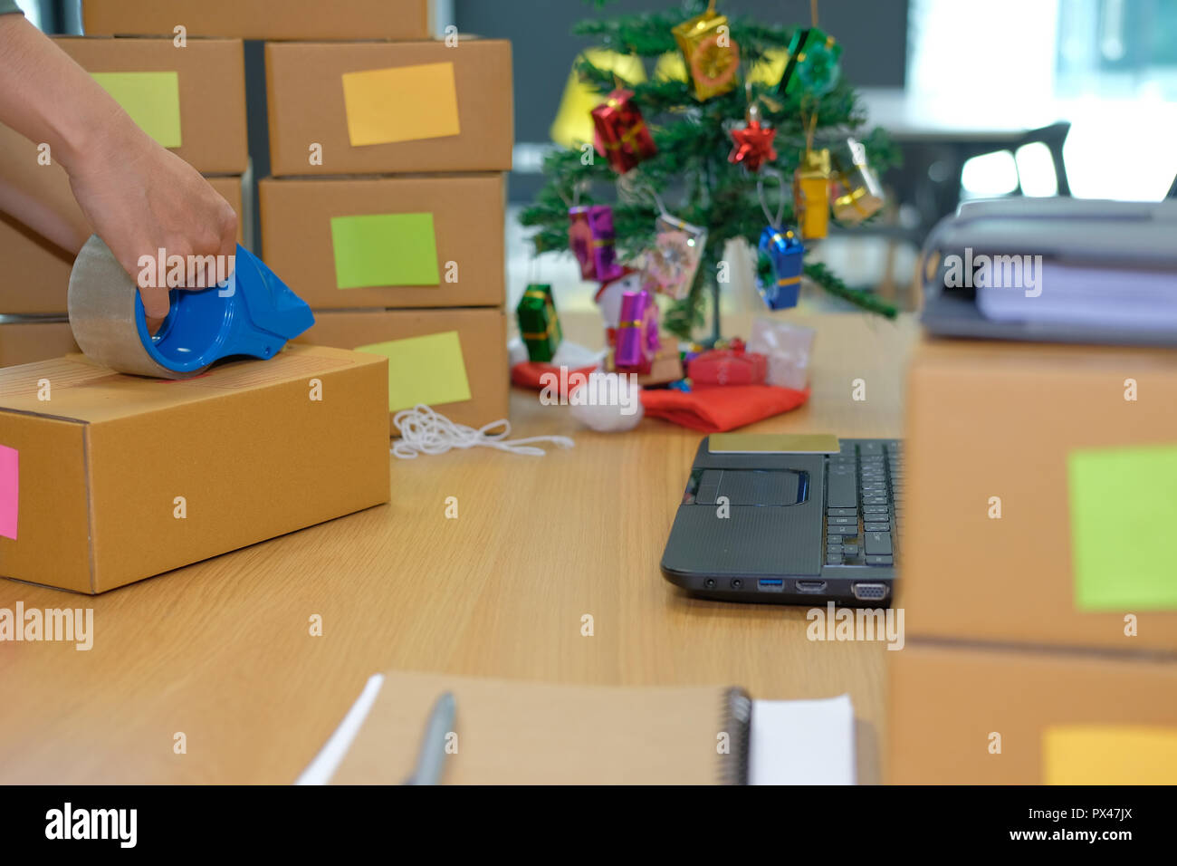 Startup titolare di una piccola azienda di imballaggio scatola di cartone al posto di lavoro. freelance imprenditore uomo venditore preparare casella di pacchi di prodotti da consegnare a personalizzato Foto Stock