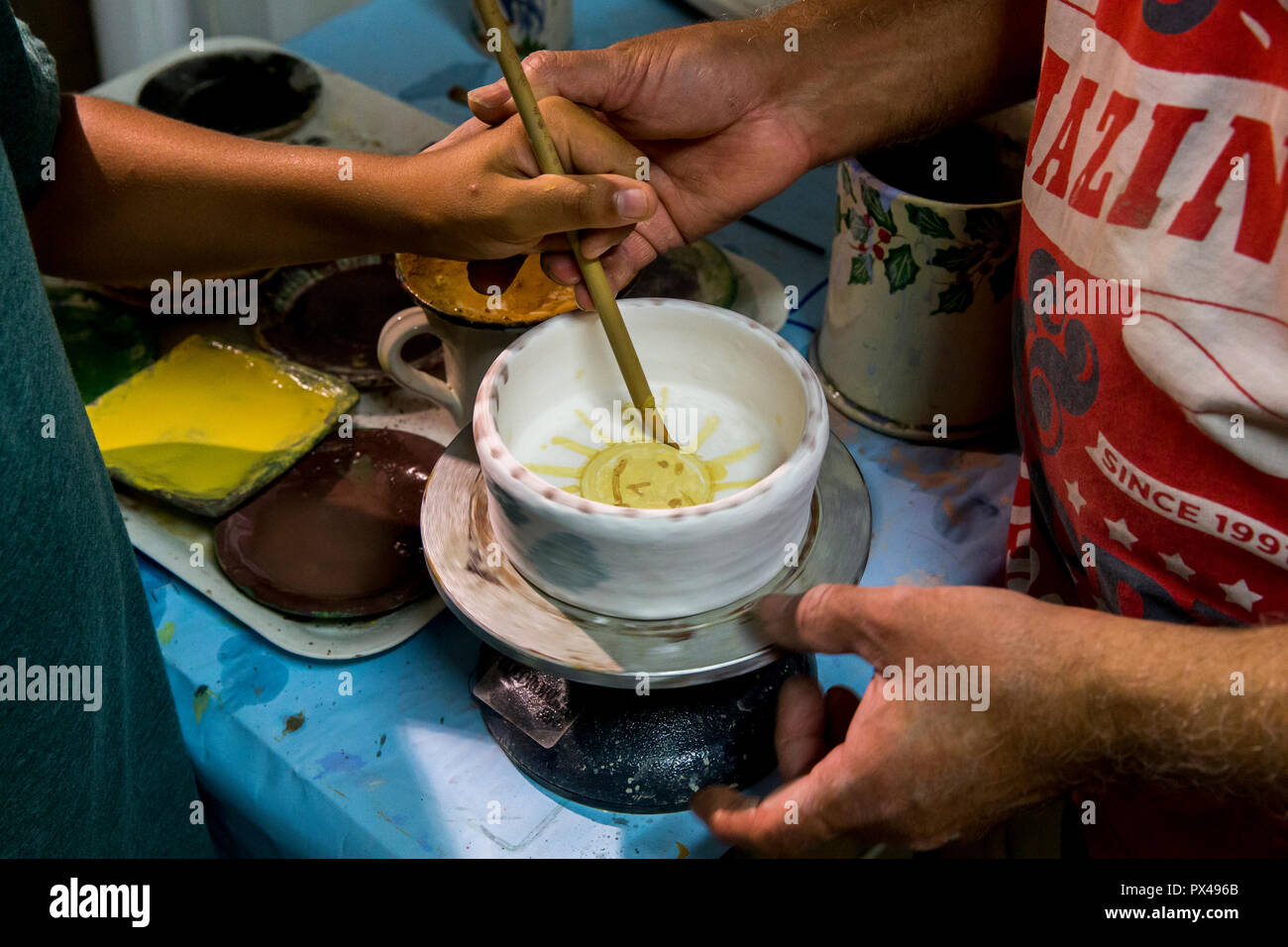 Ceramica workshop a Tricase, Puglia, Italia. Potter insegnare un bambino. Foto Stock