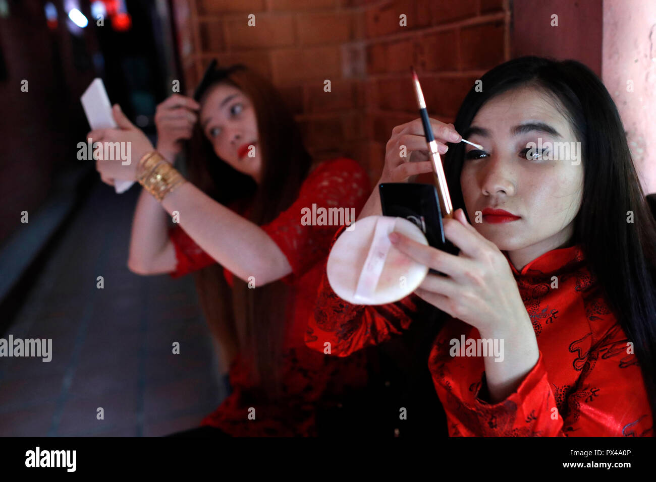 Il vietnamita ragazze con i tradizionali abiti lunghi Ao Dai fare il trucco. Ho Chi Minh City. Il Vietnam. Foto Stock