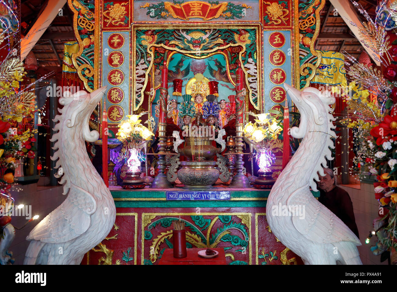 Mieu Ba Ngu Hanh tempio buddista. Altare maggiore con il rosso coronato di gru di un simbolismo della longevità e buona fortuna. Vung Tau. Il Vietnam. Foto Stock