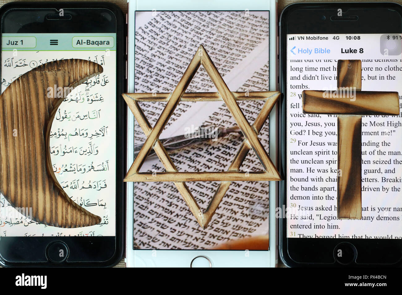 Stella ebraica, una Croce Cristiana e Musulmana e Crescent, simboli religiosi del cristianesimo, islam ebraismo impostato su 3 smartphone con app digitale. Foto Stock