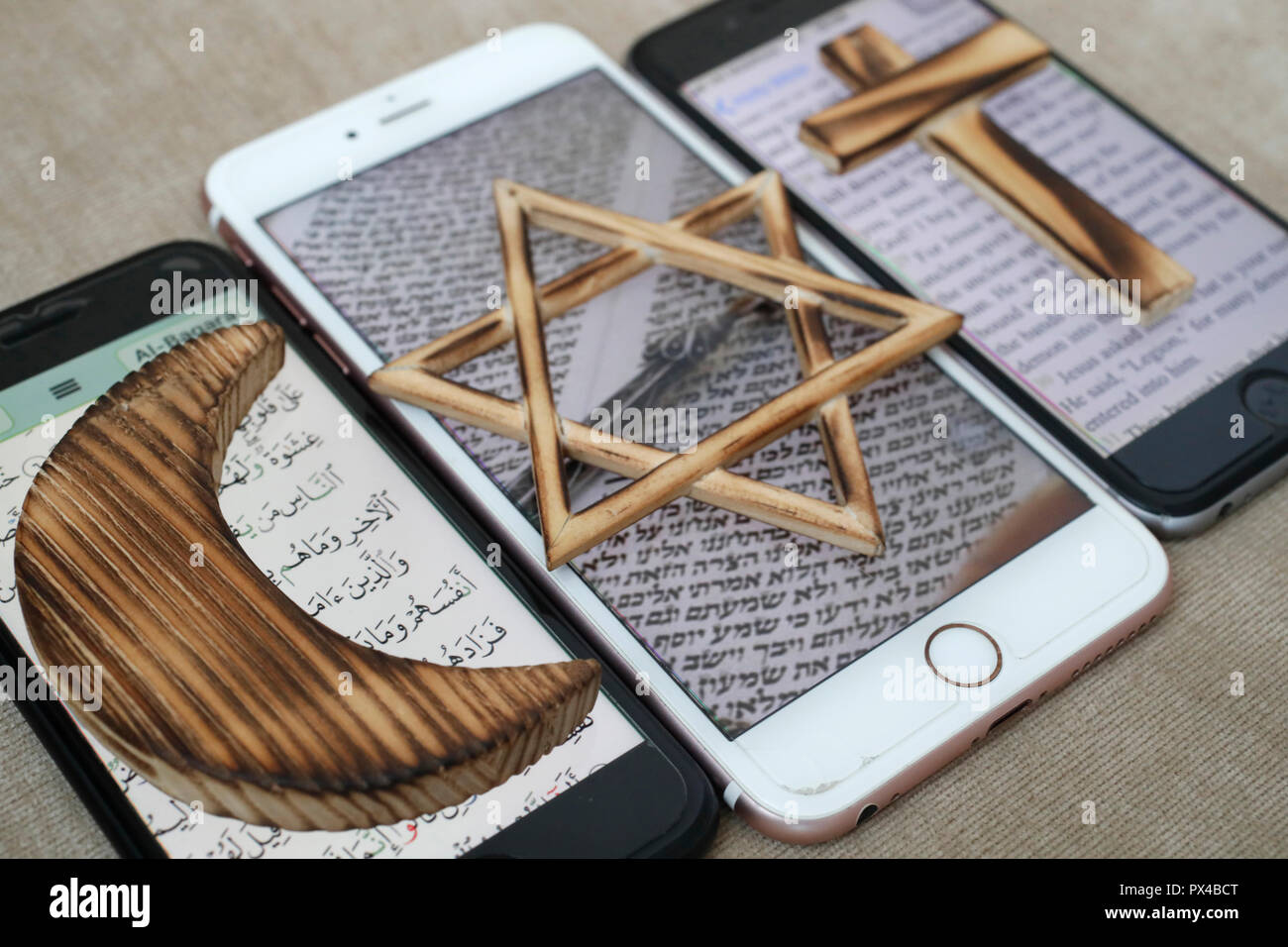 Stella ebraica, una Croce Cristiana e Musulmana e Crescent, simboli religiosi del cristianesimo, islam ebraismo impostato su 3 smartphone con app digitale. Foto Stock