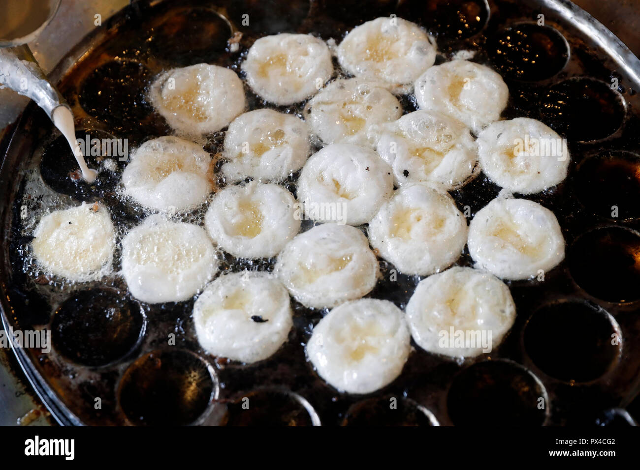 Il Vietnam Street Food: Banh Khot : mini frittelle di riso, guarnita con gamberetti, Vung Tau. Il Vietnam. Foto Stock