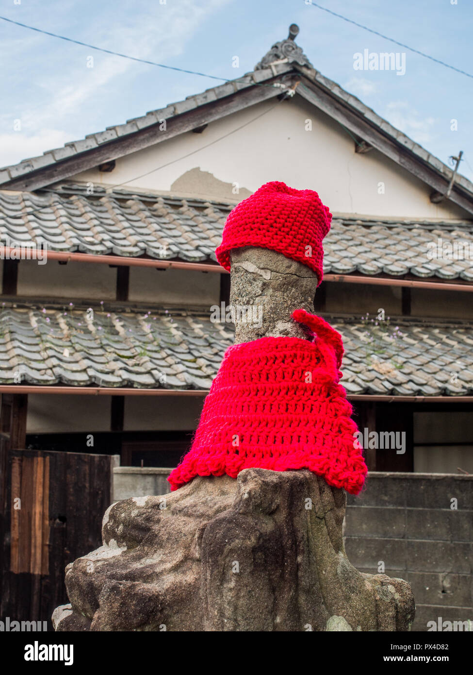 Statua sacra, usurate e vecchio, ancora curato con bib e cappuccio, Shikoku-Chuo, Ehime Giappone Foto Stock