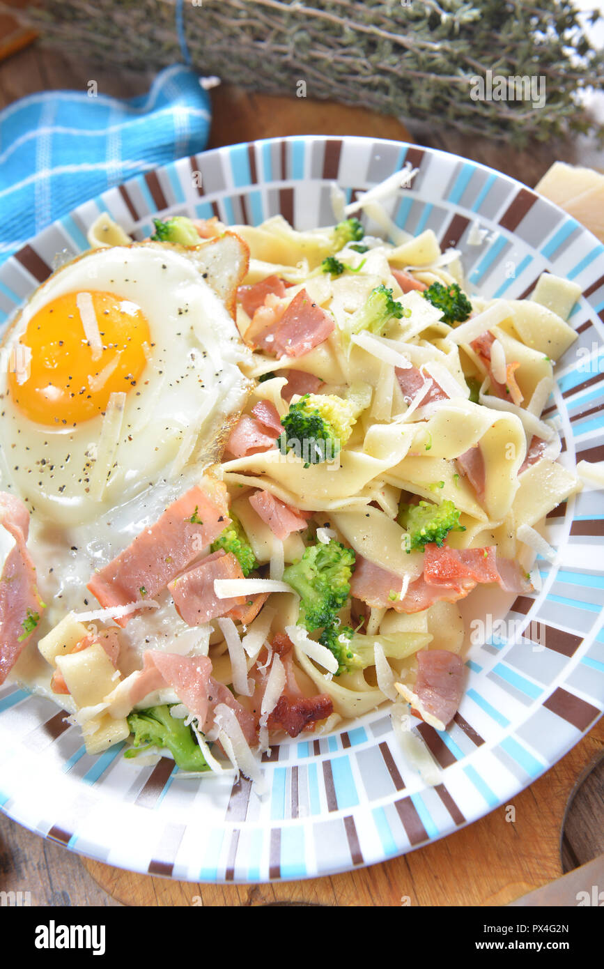 Tagliatelle con broccoli, prosciutto e uova fritte Foto Stock