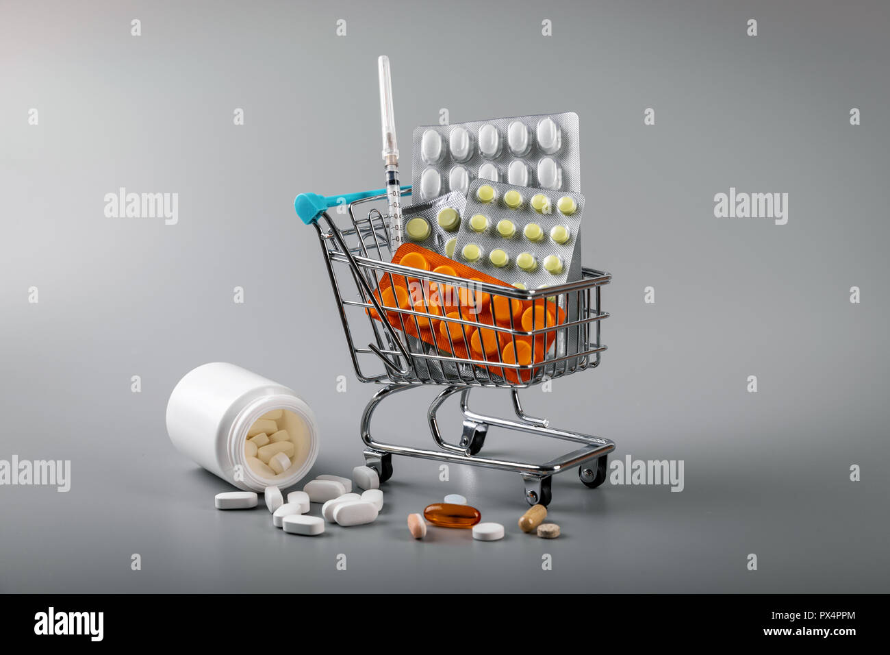 Farmacia business - carrello di pillole su sfondo grigio Foto Stock