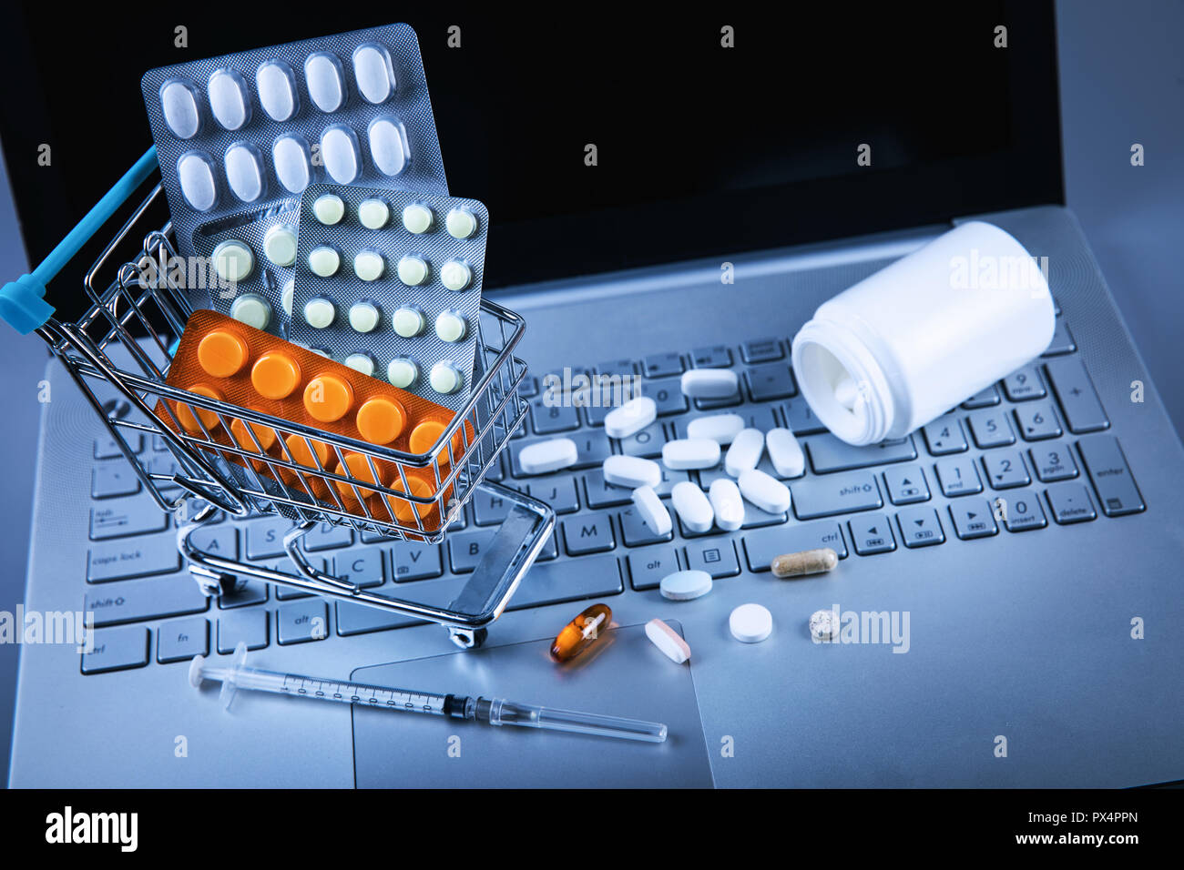 Online Pharmacy - carrello con le pillole sulla tastiera del computer Foto Stock