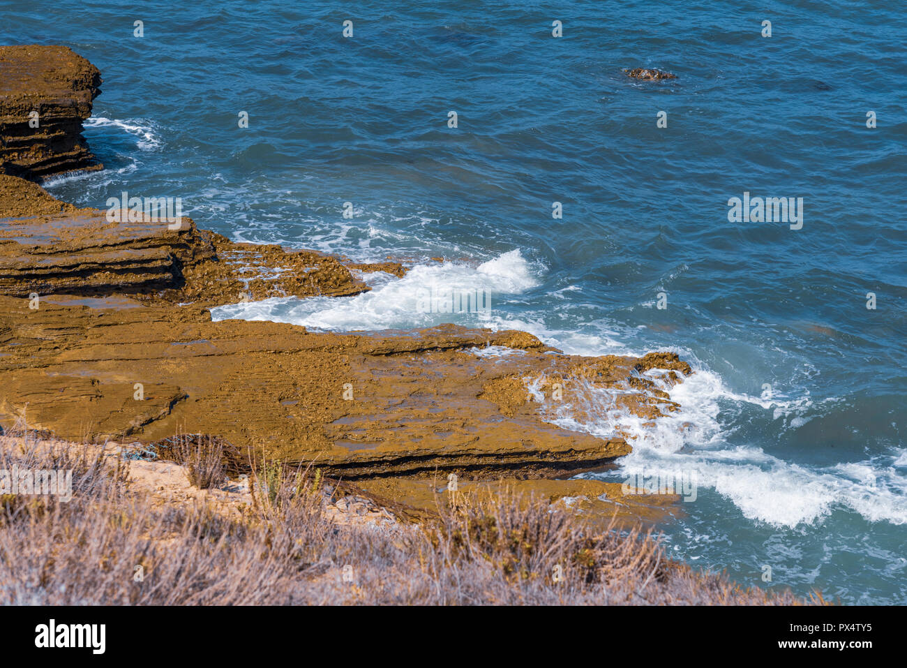Ocean onde che si infrangono sulla spiaggia rocciosa. Foto Stock