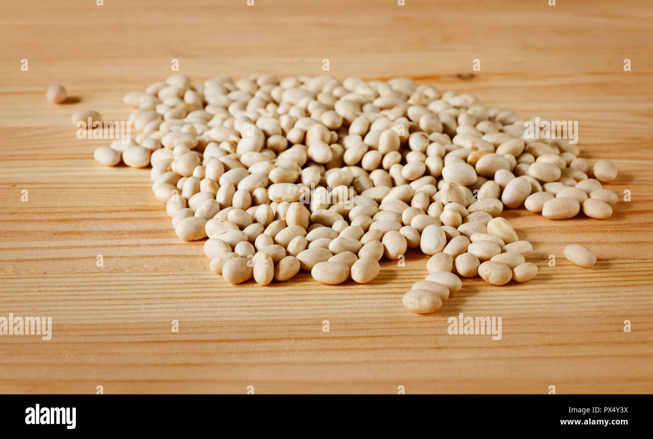 Un bel mucchio di essiccato di fagioli bianchi su una tavola di legno , vista frontale , studio shot Foto Stock