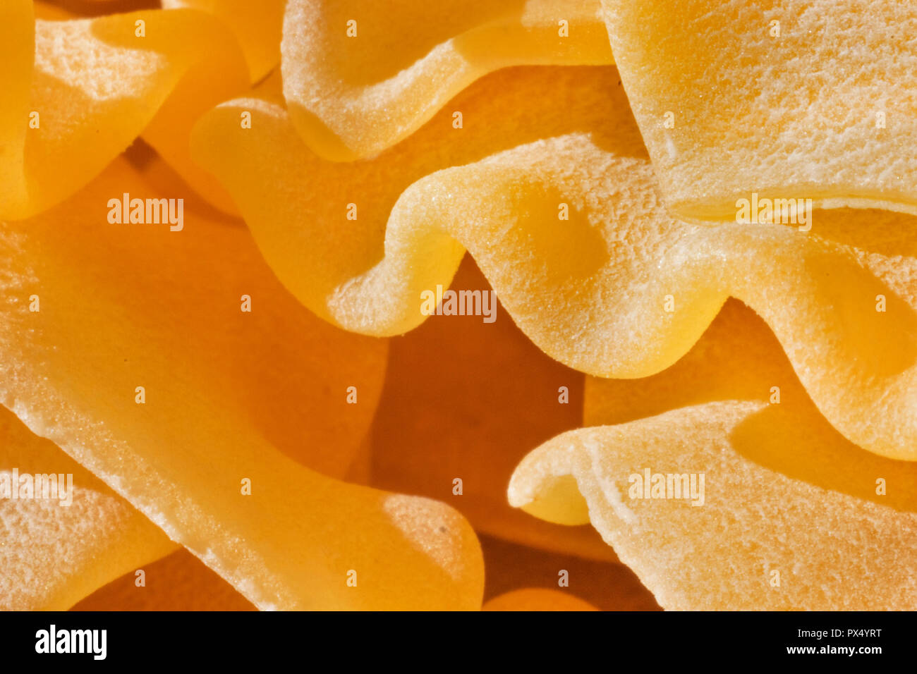 Asciugare la pasta italiana chiamato pantacce close up ,rhombus -pasta sagomata con bordo ondulato ,divertente composizione , studio shot , vista frontale , alto contrasto Foto Stock