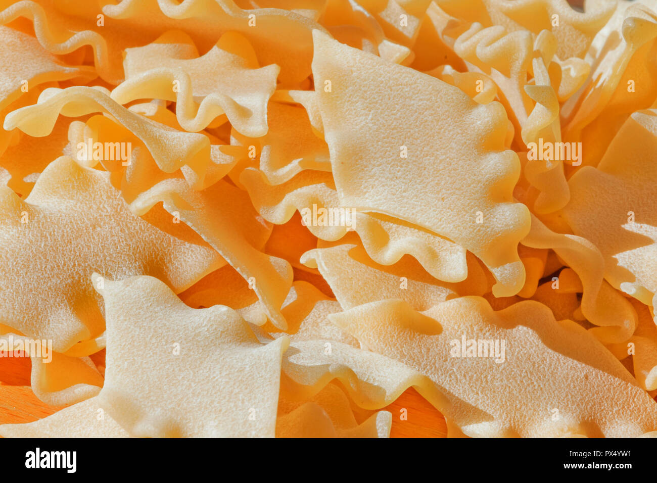 Un mucchio di asciugare la pasta italiana chiamato pantacce ,rhombus -pasta sagomata con bordo ondulato ,divertente composizione , studio shot , vista dall'alto, alto contrasto , appare Select Foto Stock