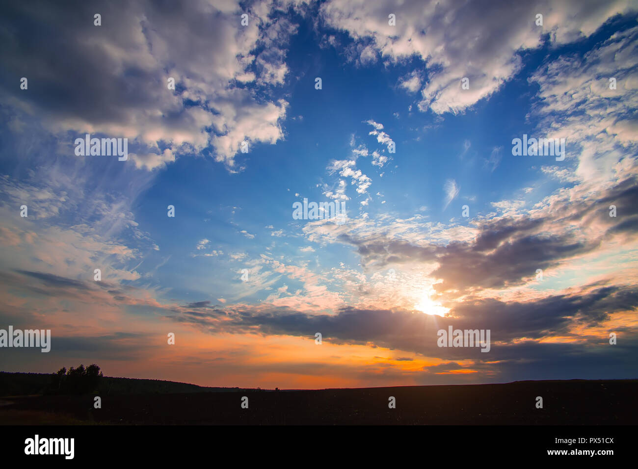 Bel tramonto in cielo molto nuvoloso nel campo Foto Stock