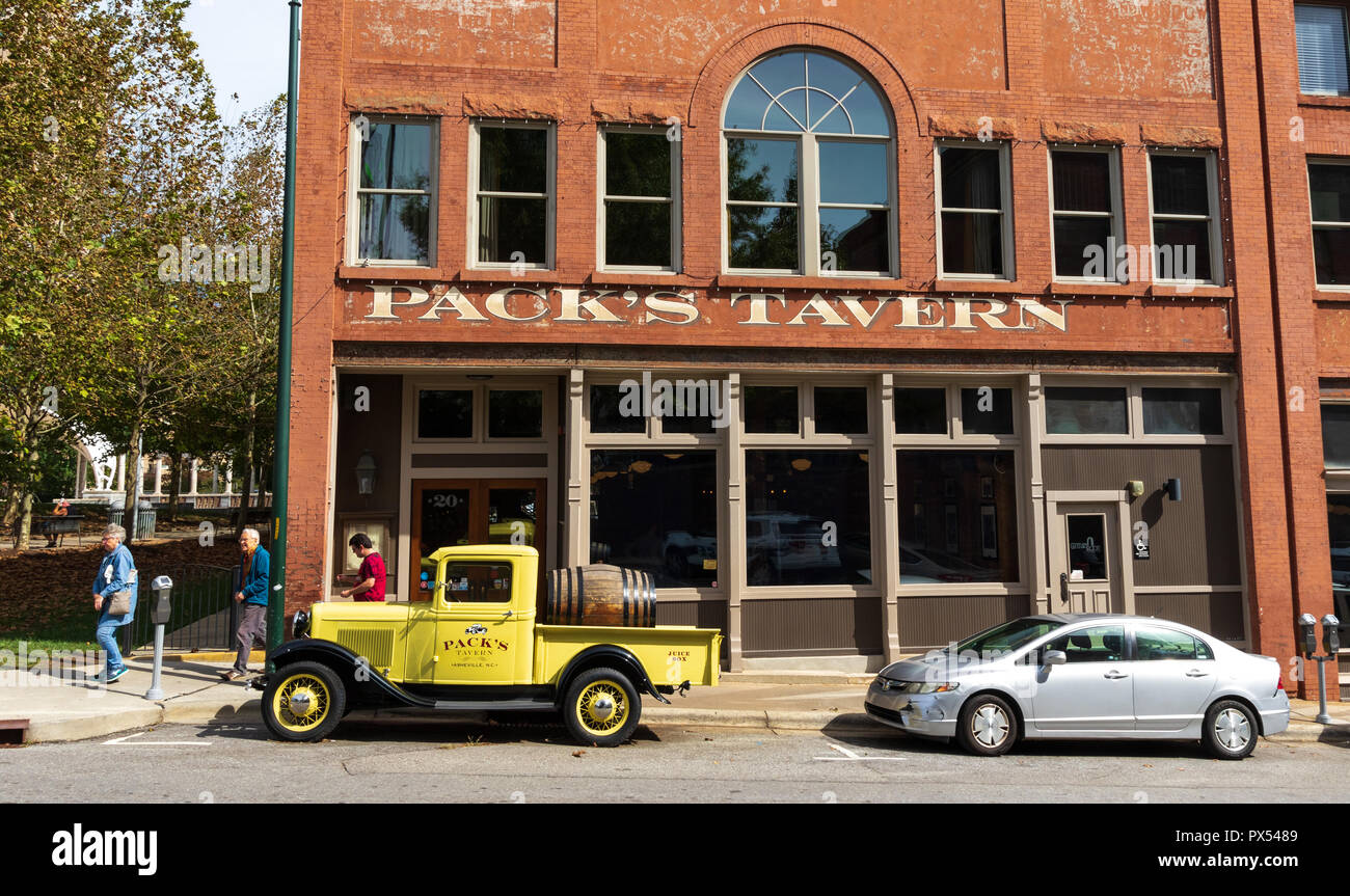 ASHEVILLE, NC, Stati Uniti d'America-10/17/18: tre persone a piedi passato Pack Taverna sulla strada di abete rosso, con pacco vintage taverna dell impostazione di prelievo davanti. Foto Stock