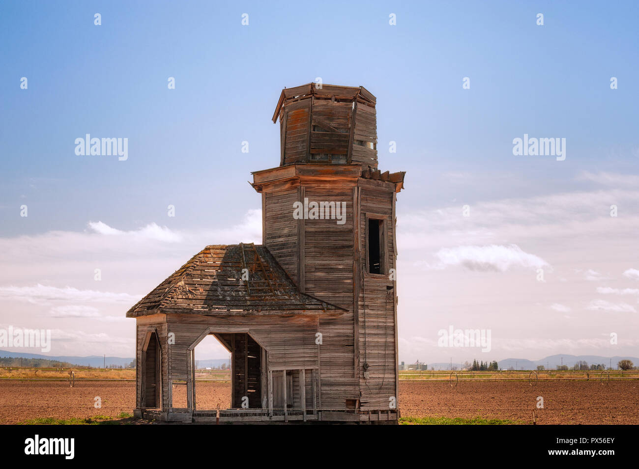 Decrittografate vecchia fattoria abbandonata la struttura ancora in piedi su un campo agricolo. Foto Stock