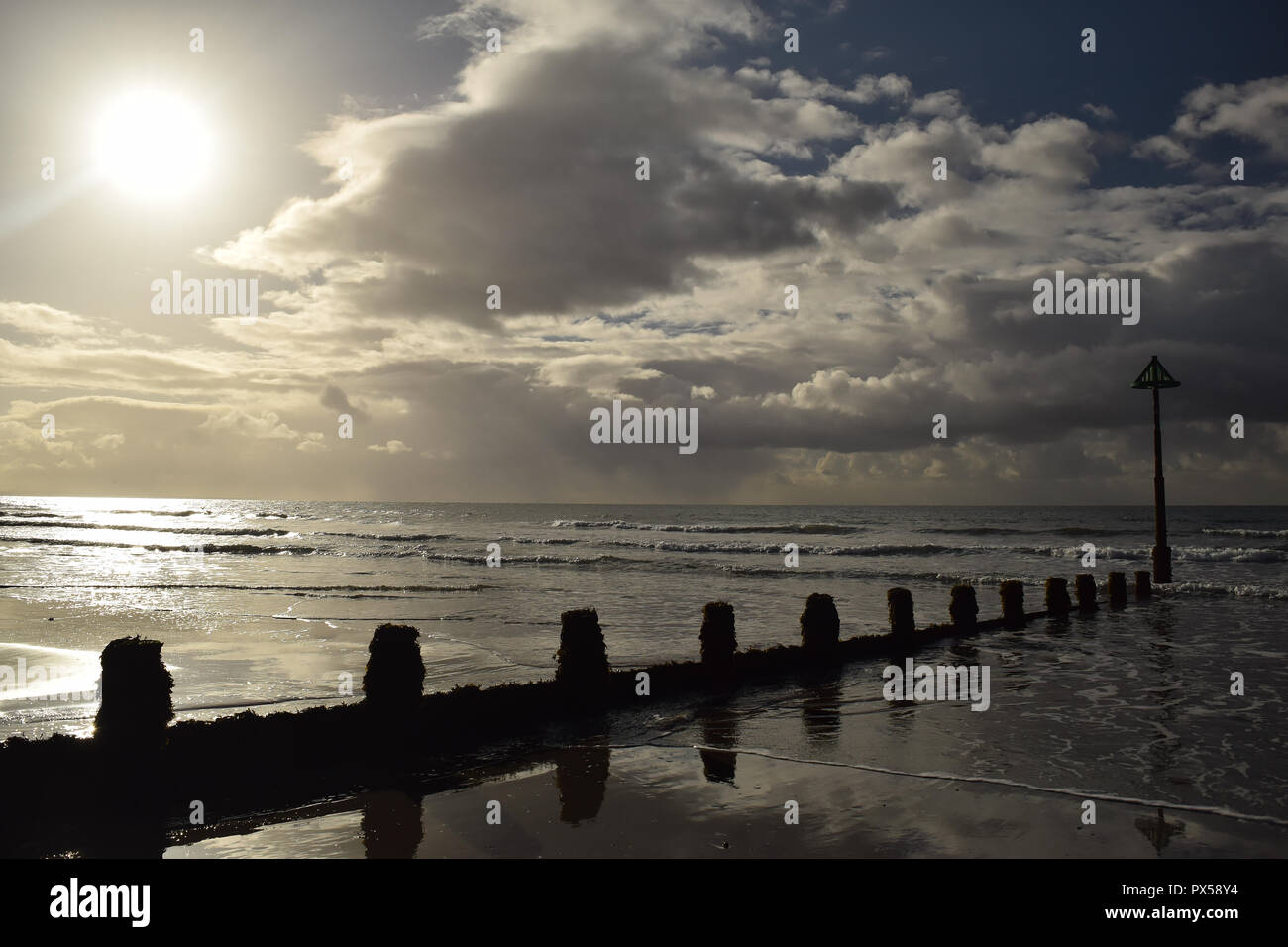 Pennelli marcatore spiaggia affacciata sul mare con nuvoloso cielo blu tra Ynyslas e Borth, Ceredigion, il Galles del Nord Foto Stock