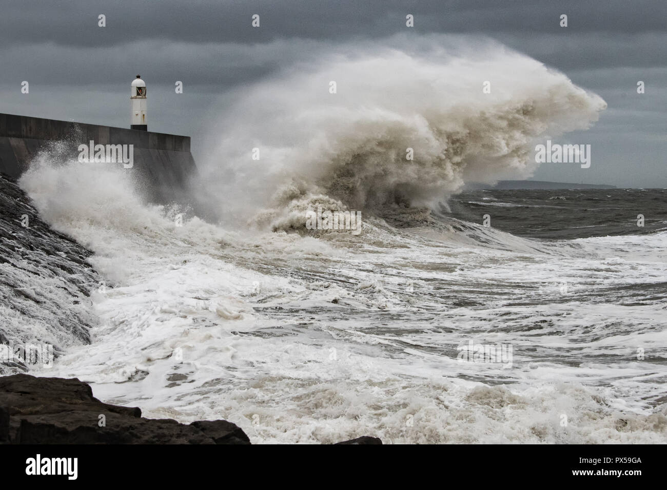 Tempesta di onde che si infrangono contro Porthcawl frangionde Foto Stock