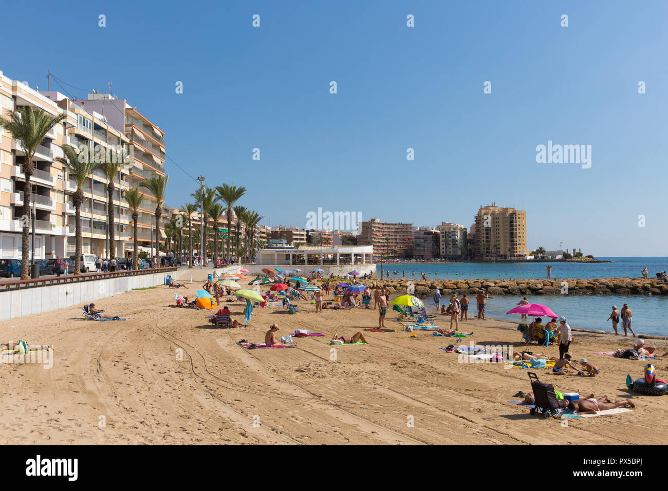 Sole spagnolo spiaggia Torrevieja in ottobre con le persone che si godono la sabbia di mare e meteo Foto Stock