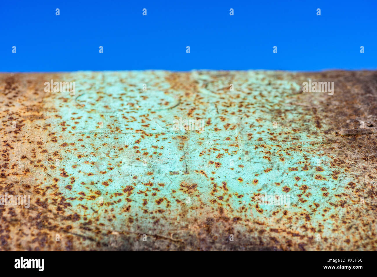 Chiudere dettaglio metallico di ruggine con la vernice verde contro lo sfondo di un cielo blu. Foto Stock