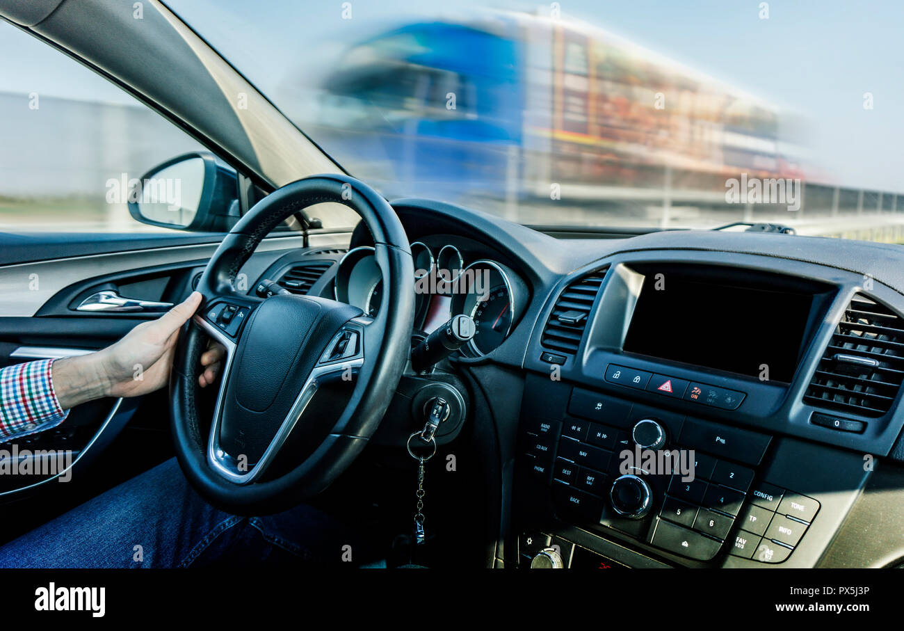 Autista guida in autostrada vista dalla vettura con un movimento di carrello sfocata in background Foto Stock