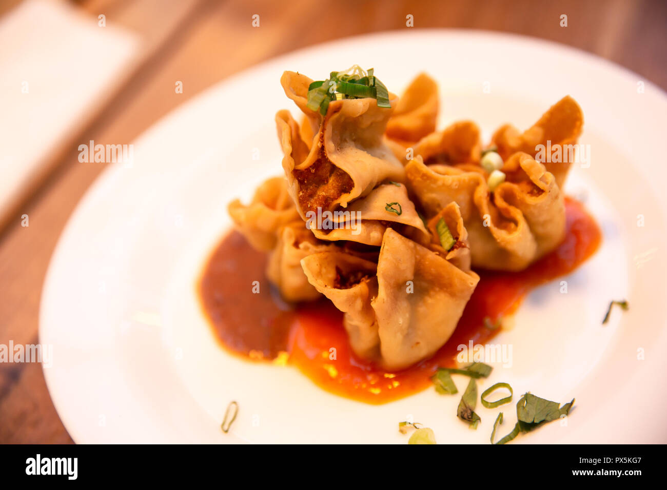Sundanese indonesiano cibo tradizionale gnocco fritto (Batagor) con arachidi e salsa di peperoncino su una piastra bianca Foto Stock