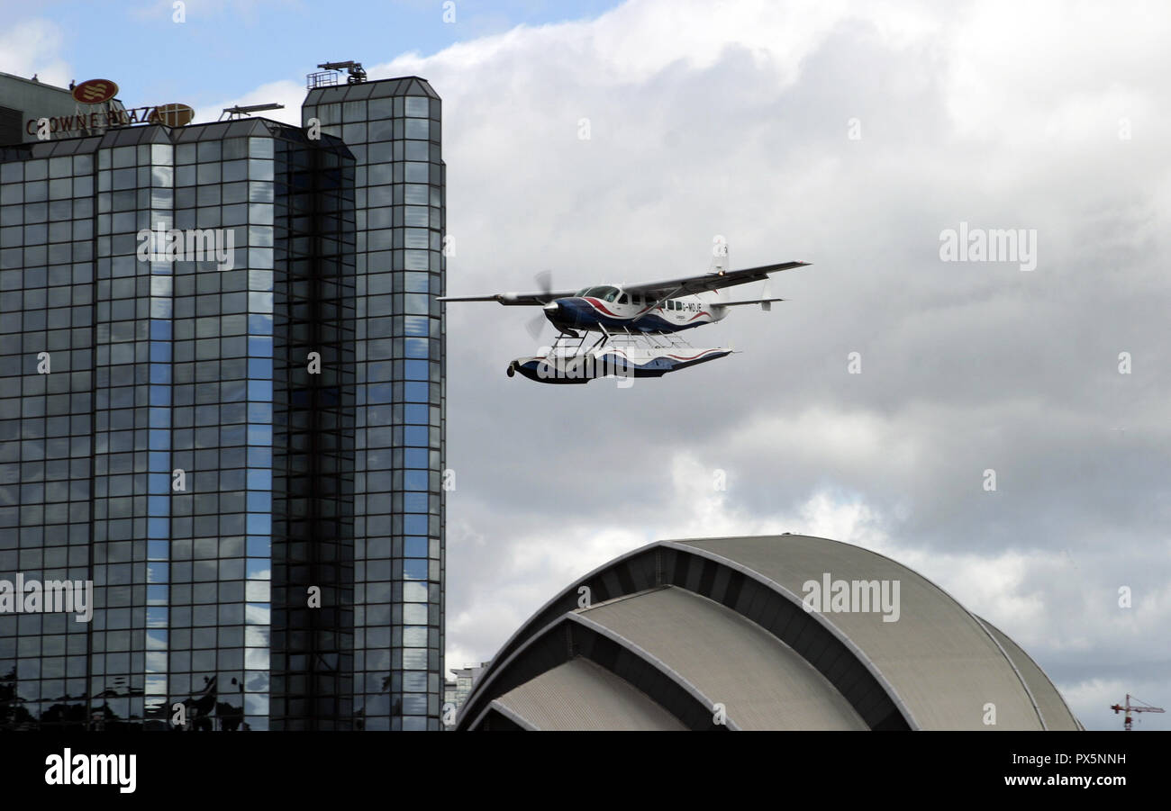 A bordo di un idrovolante sorvola la Clyde Auditorium e passato il Crowne Plaza hotel come si arriva a terra sul fiume Clyde a Glasgow, in Scozia. Foto Stock