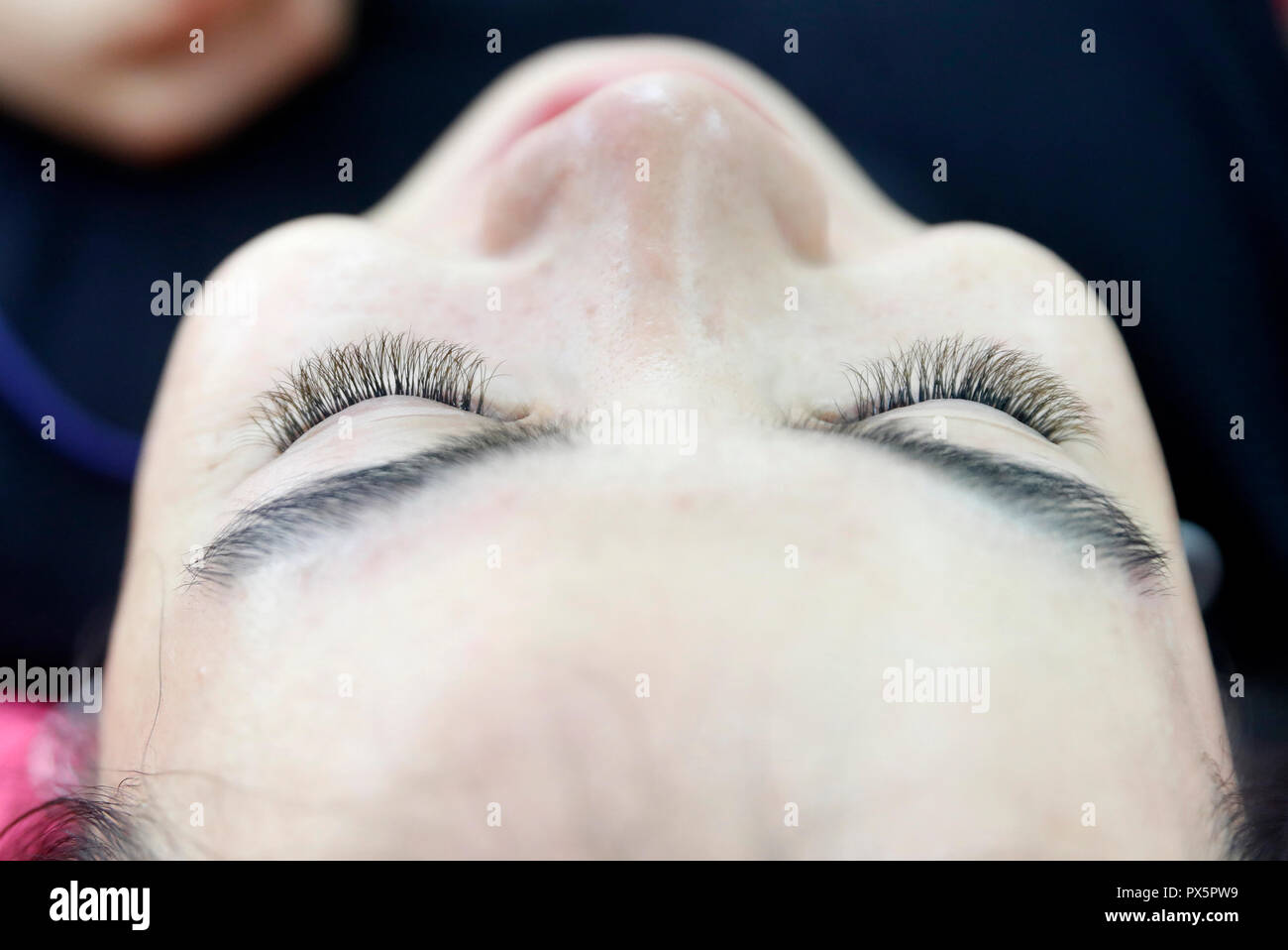 Il vietnamita salone di bellezza. Estetista applicazione ciglia estesa per donna. Ho Chi Minh City. Il Vietnam. Foto Stock