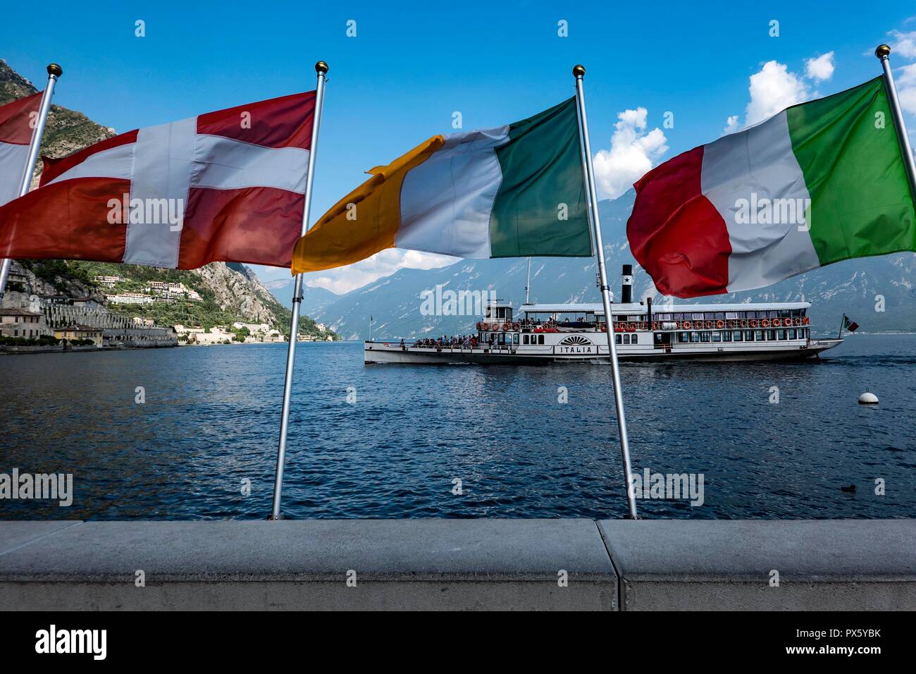 L'Italia, Garda-Lake, Limone, 09.05.2018. centro storico battello a vapore Italia avvicina il paese di Limone con bandiere di Danimarca, Irlanda e Italia in fo Foto Stock