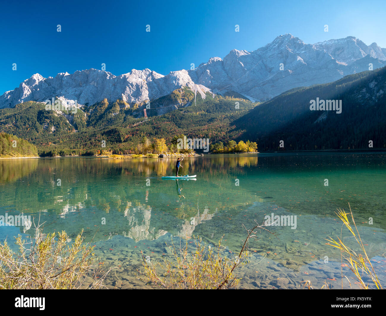Immagine di stand up paddling su un bellissimo lago di montagna in autunno Foto Stock