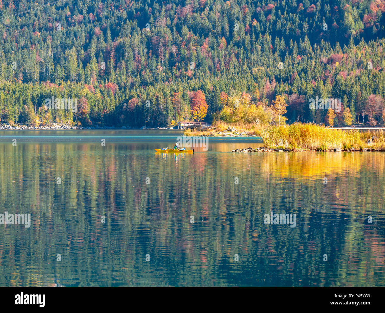 Immagine di kayaker su di una tranquilla montagna lago in autunno Foto Stock
