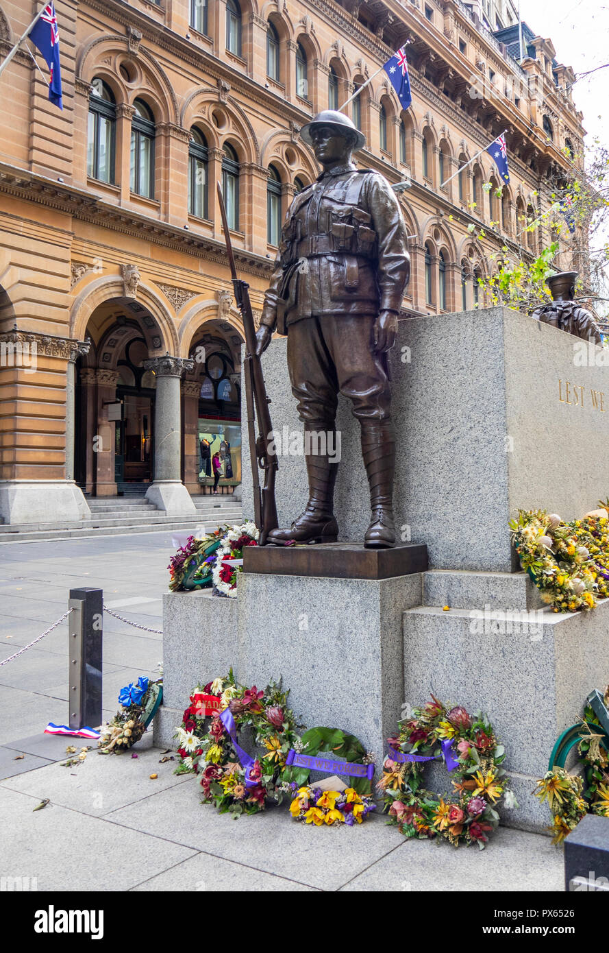 Ghirlande poste alla base della statua di bronzo di un soldato di commemorazione Anzac Day in Martin Place Sydney NSW Australia. Foto Stock