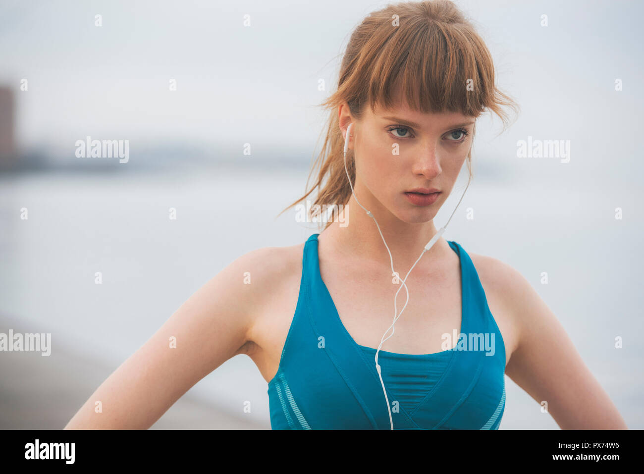 In prossimità di una donna determinata atleta che corre in riva al mare in città urbana ambiente Foto Stock